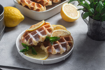 Belgian waffles made from cottage cheese with mint and lemon in a white plate on the table. Healthy breakfast