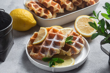 Belgian waffles made from cottage cheese with mint and lemon in a white plate on the table. Healthy breakfast