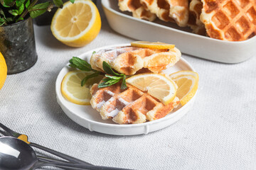 Belgian waffles made from cottage cheese with mint and lemon in a white plate on the table. Healthy breakfast