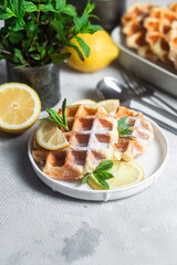 Belgian waffles made from cottage cheese with mint and lemon in a white plate on the table. Healthy breakfast
