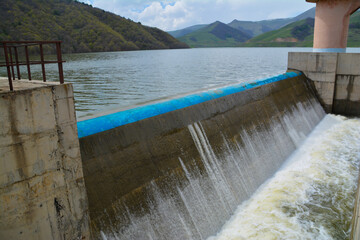 Reservoir and dam. Lighthouse in the reservoir. Lake in the mountains. Waterfall in the reservoir...