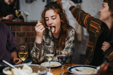 A group of friends sitting around a table enjoying a meal in a casual and cozy atmosphere, with...