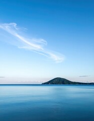 A picturesque small island nestled in the serene waters of Lake Malawi, surrounded by lush greenery and vibrant tropical plants, under a clear blue sky.