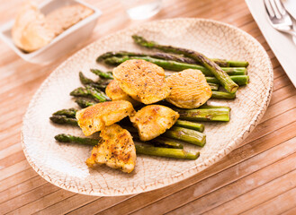 Cooked dish. Chicken nuggets with green asparagus on plate