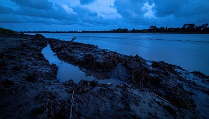 Serene Riverbank at Twilight with Moody Blue Skies and Reflections