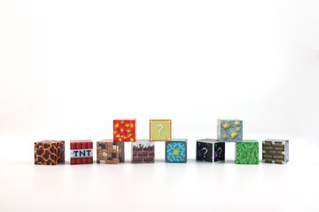 Fototapeta premium minecraft magnetic building toy blocks , from online virtual world game series are display on white table with many kinds of minecraft blocks , tnt magma stone wood grass water and cute characters