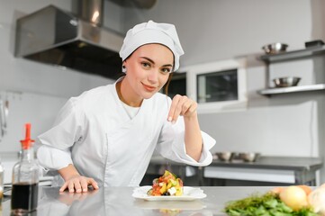 Female chef in kitchen. Cooking concept