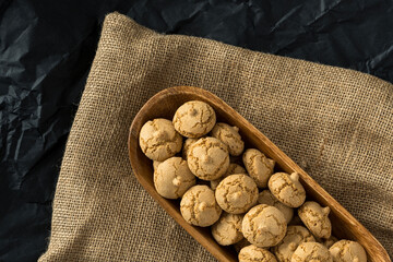 Amaretti cookie in a wooden bowl on a burlap background , top view , high-resolution . Delicious ,...