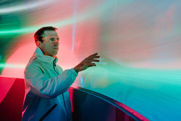 Man looking at the glowing screen using futuristic glasses