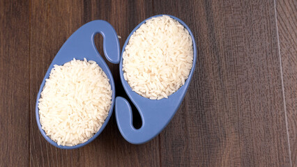 Healthy food. Wooden bowl with parboiled rice on white background. Top view, copy space, high resolution product.
