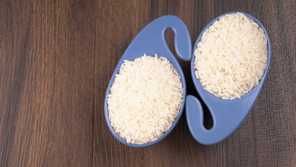 Healthy food. Wooden bowl with parboiled rice on white background. Top view, copy space, high resolution product.
