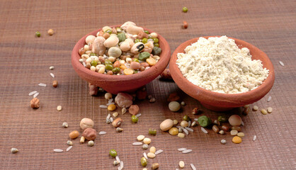 Uncooked pulses,grains and seeds in colourful bowl over wooden background. selective focus
