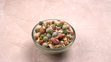 Uncooked pulses,grains and seeds in colourful bowl over wooden background. selective focus