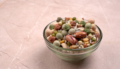 Uncooked pulses,grains and seeds in colourful bowl over wooden background. selective focus