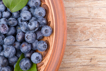 Blueberries in a bowl on wooden table. Top view with copy space