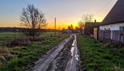 Fototapeta premium Serene Country Road at Sunset with Vibrant Sky and Reflection