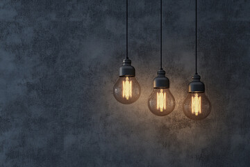 Three Edison bulbs hang against a dark textured wall illuminating the space softly