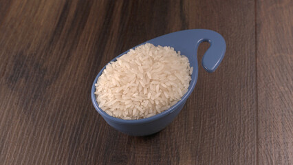Healthy food. Wooden bowl with parboiled rice on white background. Top view, copy space, high resolution product.
