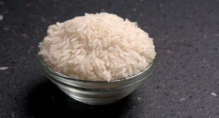 Healthy food. Wooden bowl with parboiled rice on white background. Top view, copy space, high resolution product.
