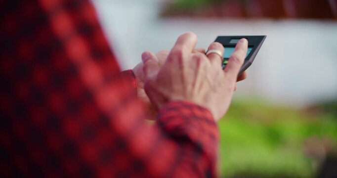 Gardener Using Calculator for Business Expenses