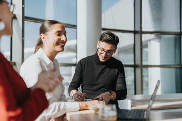 Business employees enjoying a collaborative discussion in a bright office kitchen environment. Professionals are engaged, smiling, and working together, fostering teamwork and communication in a