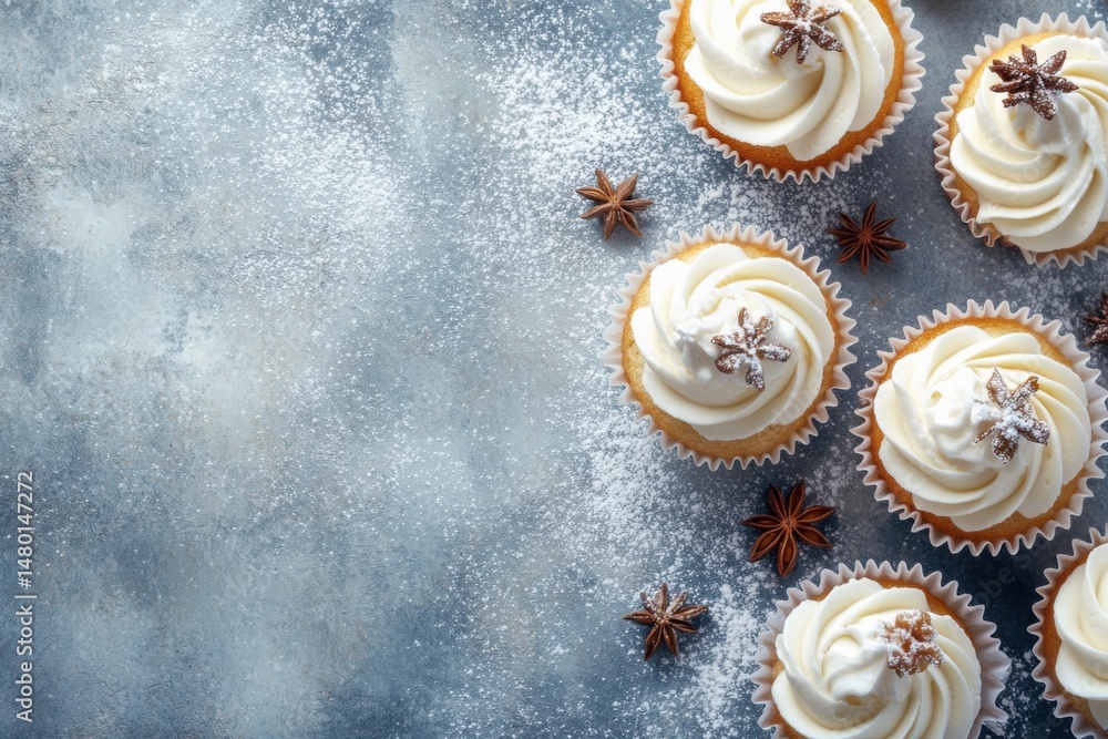 Poster overhead view of vanilla cupcakes with white frosting and star anise on a textured gray surface dust