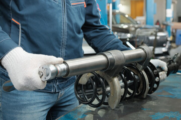 Car service. Car suspension repair.An auto mechanic prepares the replacement of the shock strut.