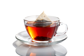 A clear glass cup of tea with a tea bag sitting on a clear saucer against a black background