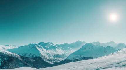 Sunlit snow-covered mountain range in winter.