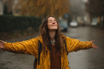 Woman in yellow raincoat standing in the rain.