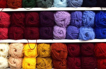 Shop shelves with multicolored skeins of yarn for knitting. Yarn for knitting for needlework....