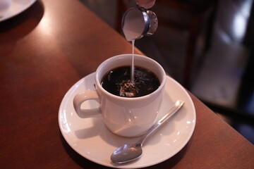 Image of Coffee with Milk being added - 喫茶店 コーヒーにミルクを注ぐ
