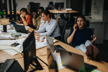 Multicultural group of business professionals collaborate late at night, surrounded by laptops and documents. They engage in productive discussions and strategic planning to meet impending deadlines.