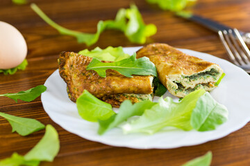 Homemade omelette roll with salad and green leaves
