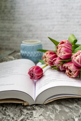 Pink tulips, an open book and a mug of freshly brewed coffee or tea. Spring set. Flatley layout.