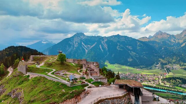 Approaching the ruins of Ehrenberg Castle in Reutte, Tyrol, Austria. Spectacular mountains at backdrop under the grey cloudscape. Aerial perspective.
