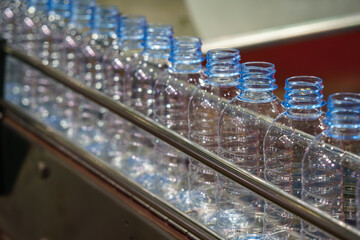 The  empty drinking water bottles on the conveyor belt for filling process.