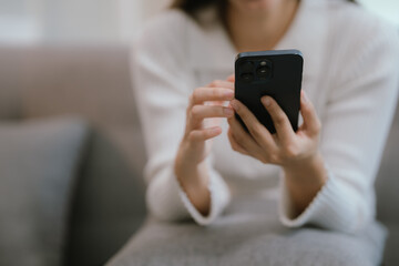 Close-up of a young woman's hand holding a smartphone and chatting on social media.