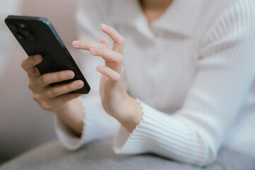 Close-up of a young woman's hand holding a smartphone and chatting on social media.