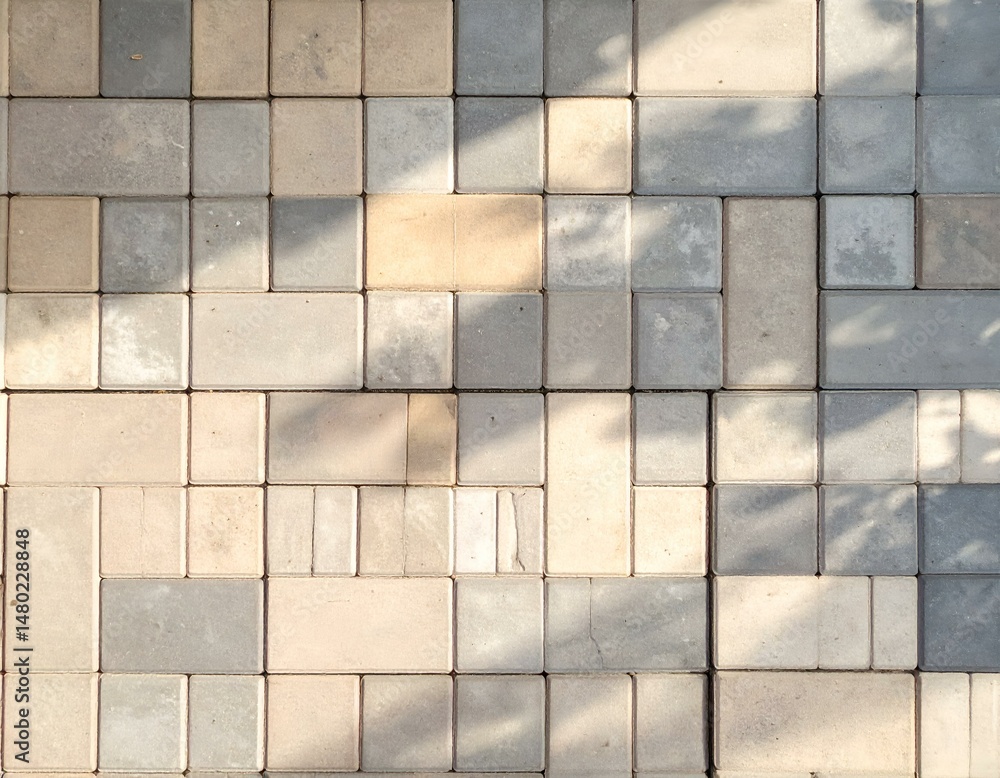 Poster sunlit paving stones, various shades of beige and grey, create a textured pattern. ideal for backgro