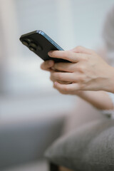 Close-up of a young woman's hand holding a smartphone and chatting on social media.