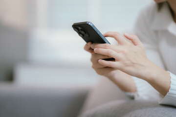 Close-up of a young woman's hand holding a smartphone and chatting on social media.