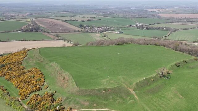 An aerial view rotating showing the top and sides of the remains of the Iron Age Hillfort in rural Leicestershire, UK in springtime