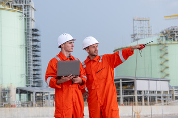 Industry workers collaborate on site while overseeing operations at a modern facility during...