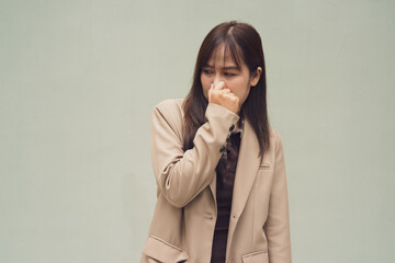 portrait of a young woman looking disgusted holding her nose