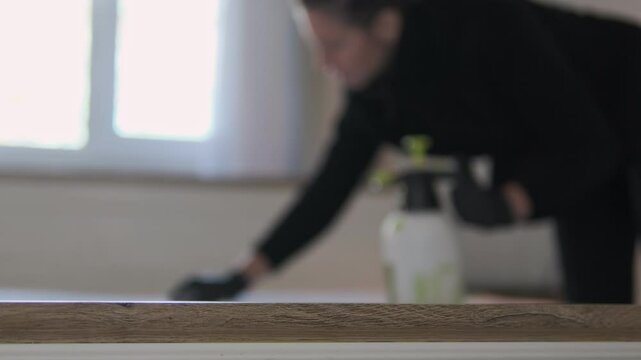Realistic footage of mattress cleaning at home. A woman uses a brush and spray to remove stains from the fabric. Face is blurred. Perfect for home hygiene concepts, advertising, and text overlay.