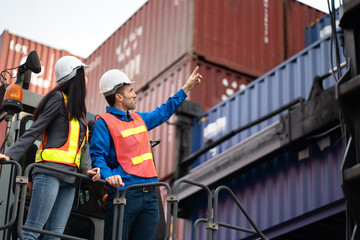 Caucasian man and woman engineer worker working and talking together with Reach Stacker at...