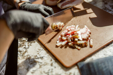 A skilled chef, wearing neat gloves, expertly chopping fresh ingredients on a rustic wooden cutting board