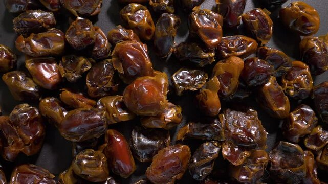 Dried dates, top view. On a turntable, spinning in motion. Slow motion