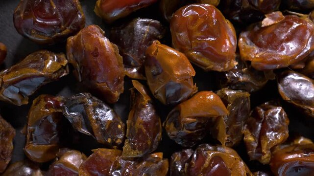 Dried dates, close-up macro shot, top view. On a turntable, spinning in motion. Slow motion